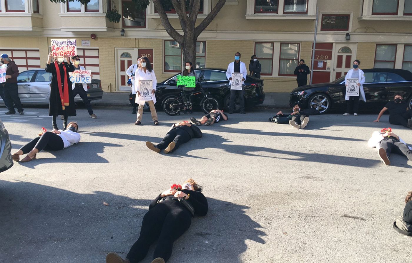 Protesters Stage 'Die-In' Over Homeless Hotel Issue Outside Mayor's Home